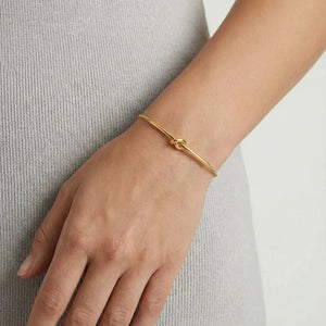 Gold knot bar bracelet on wrist, delicate chain, minimalist jewelry style