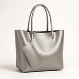 Elegant large-capacity tote bag made from genuine cowhide leather, bucket-style design with soft polyester-cotton lining, available in black, gold, and silver.