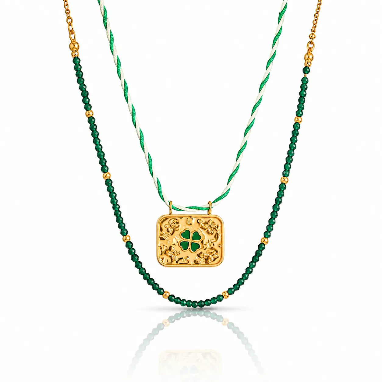 A double-strand St. Patrick's Day necklace featuring a gold filigree clover pendant and a green beaded strand layered over a white and green twisted cord chain.