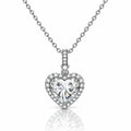 A heart-shaped diamond pendant necklace on a silver chain, set against a clean white background with a soft reflection below.