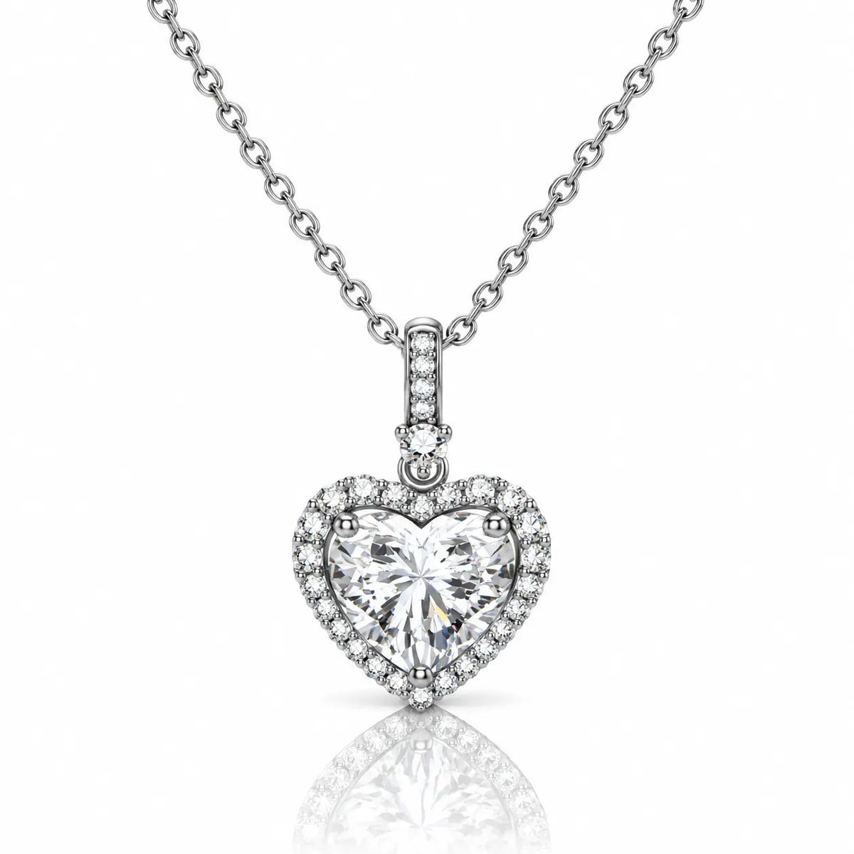 A heart-shaped diamond pendant necklace on a silver chain, set against a clean white background with a soft reflection below.