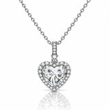 A heart-shaped diamond pendant necklace on a silver chain, set against a clean white background with a soft reflection below.