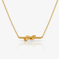 Gold necklace with a knot design on a white background