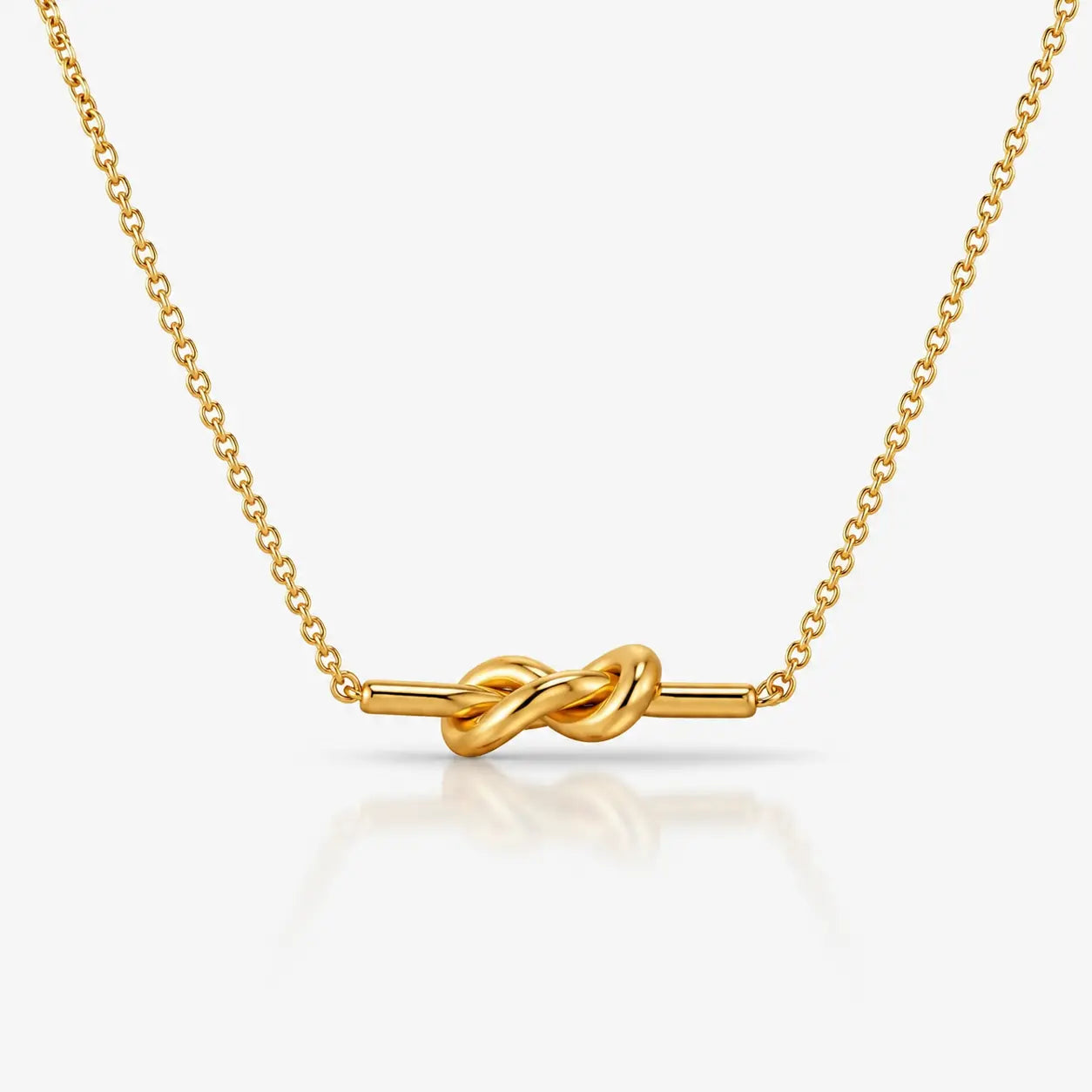 Gold necklace with a knot design on a white background