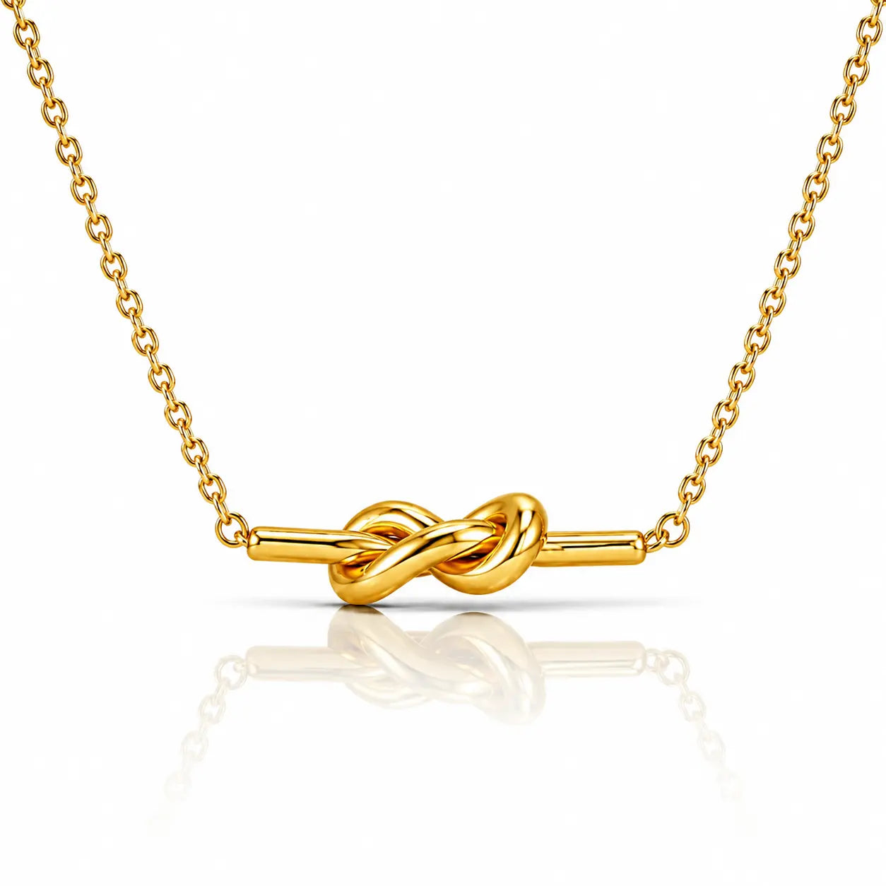 A gold necklace with a polished knot pendant on a fine link chain, displayed against a clean white background with a soft reflection below.