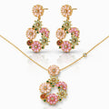 Floral jewelry set with pink and green gemstones on a white background
