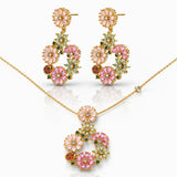 Floral jewelry set with pink and green gemstones on a white background