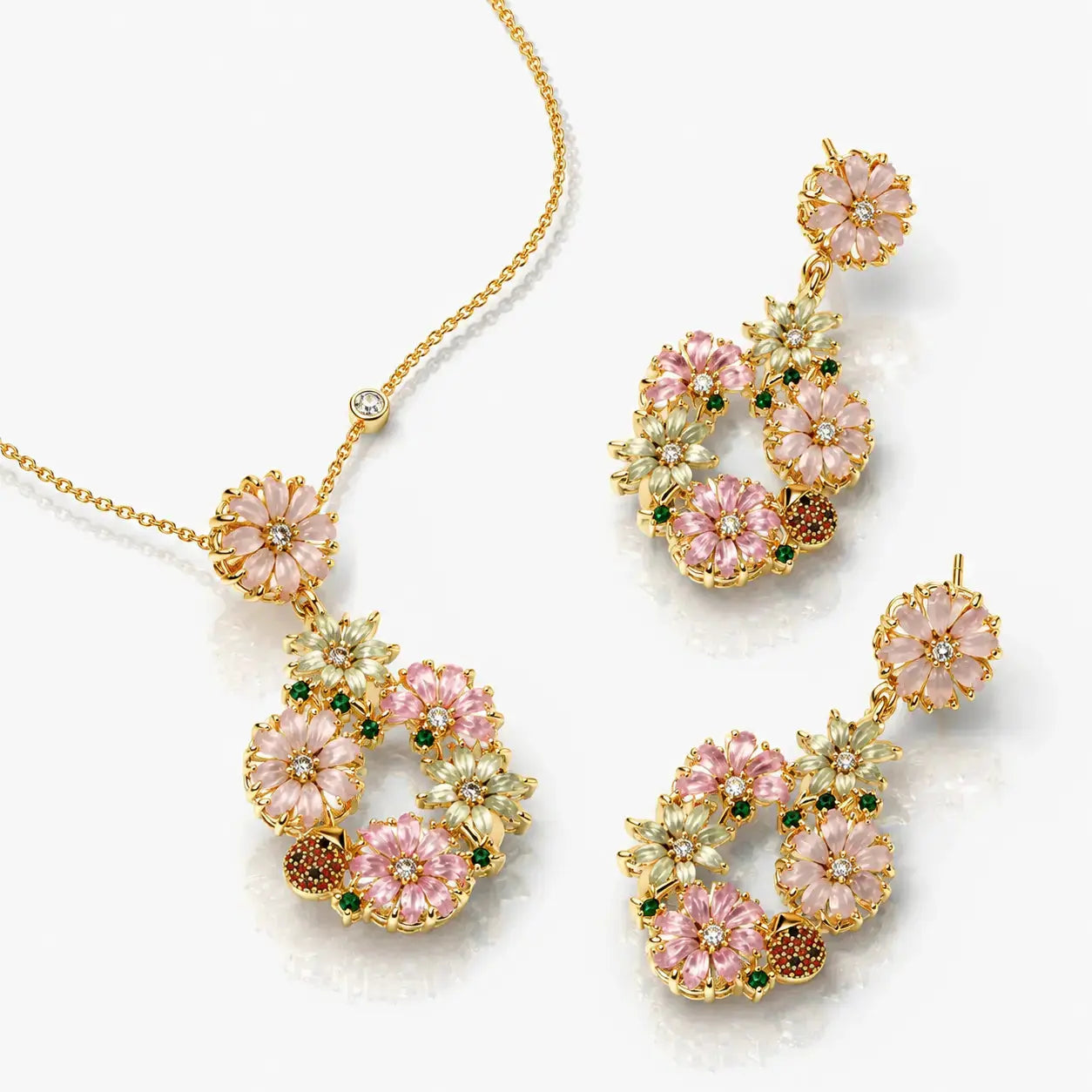 Gold and pink floral jewelry set on a white background