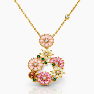 Gold necklace with pink floral pendants on a white background