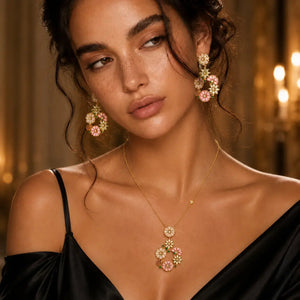 Woman wearing floral earrings and a necklace with a warm, blurred background