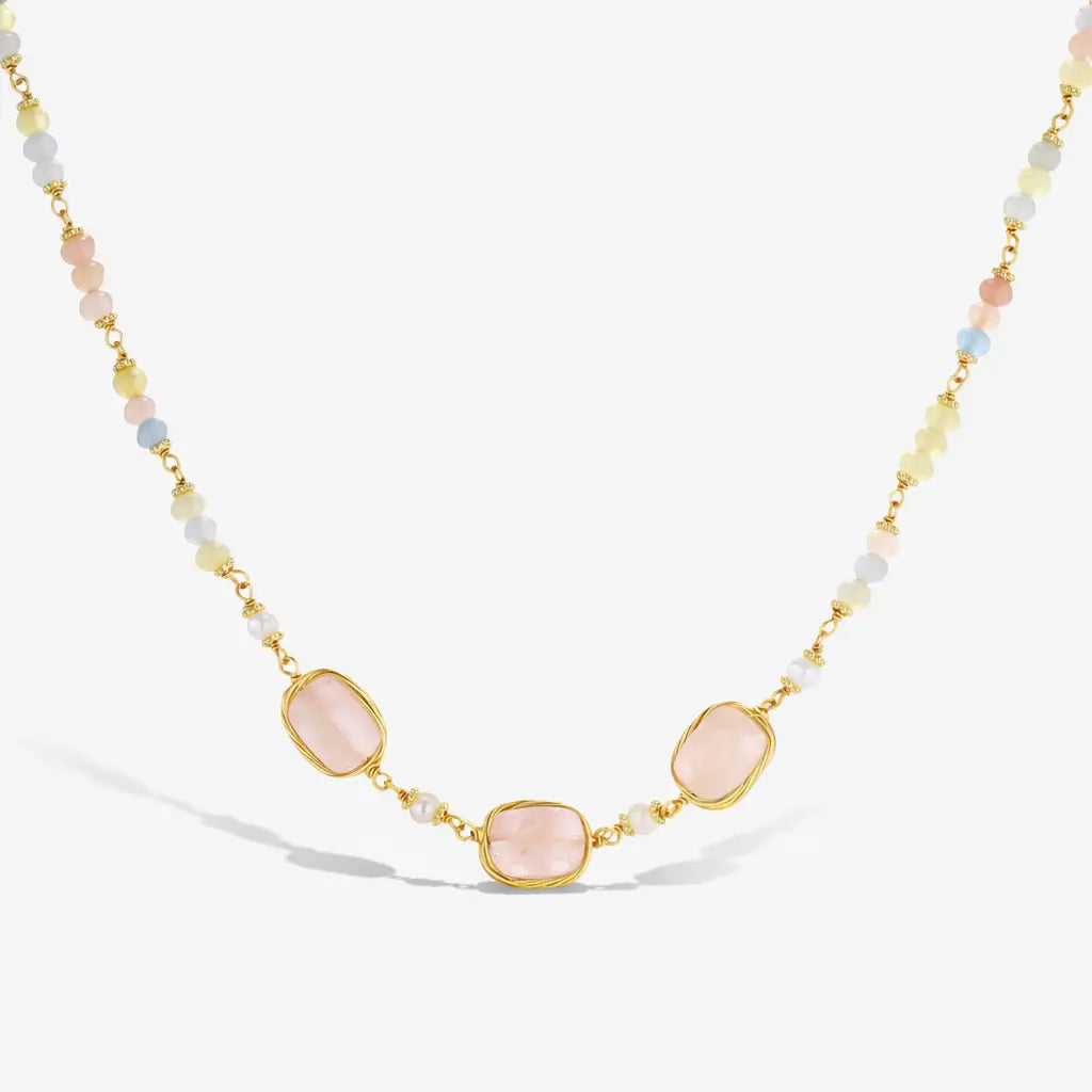 Necklace with pink stones and gold accents on a white background