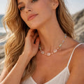Woman wearing a necklace with a scenic background