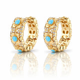 Gold hoop earrings with blue gemstones on a white background