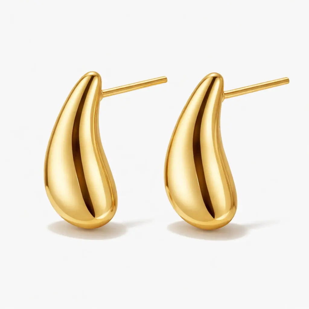 Pair of gold teardrop stud earrings on white background