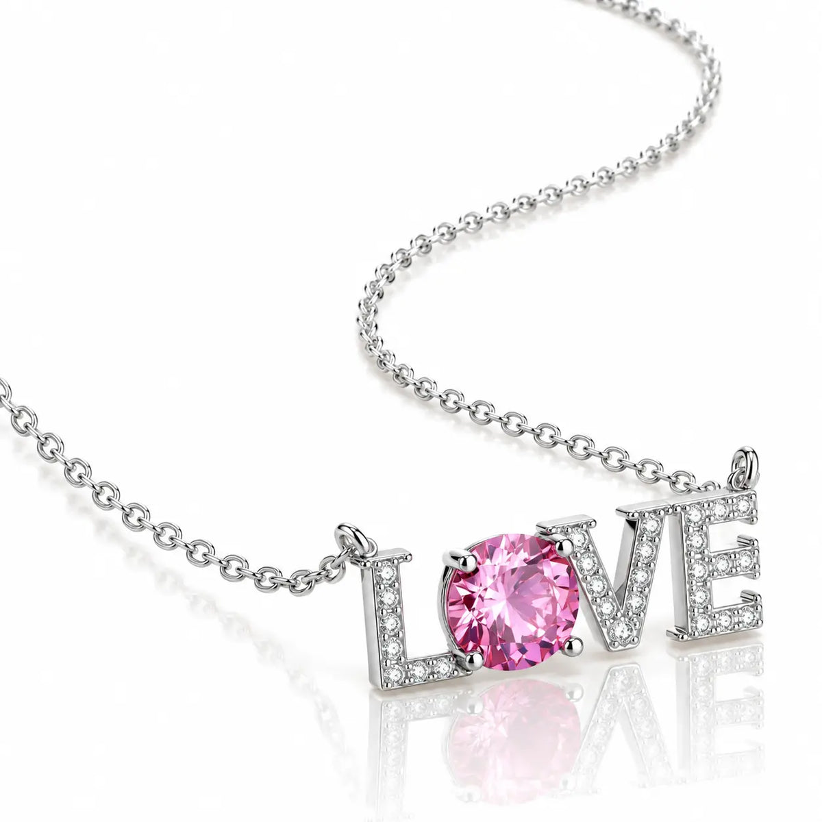 A silver-tone necklace featuring a 'LOVE' word pendant, where the letter 'O' is replaced by a round pink gemstone, set against a clean white background with a soft reflection.