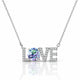 A silver-tone necklace featuring the word 'LOVE' with the letter O replaced by a large round iridescent gemstone, set against a clean white background with a soft reflection below.