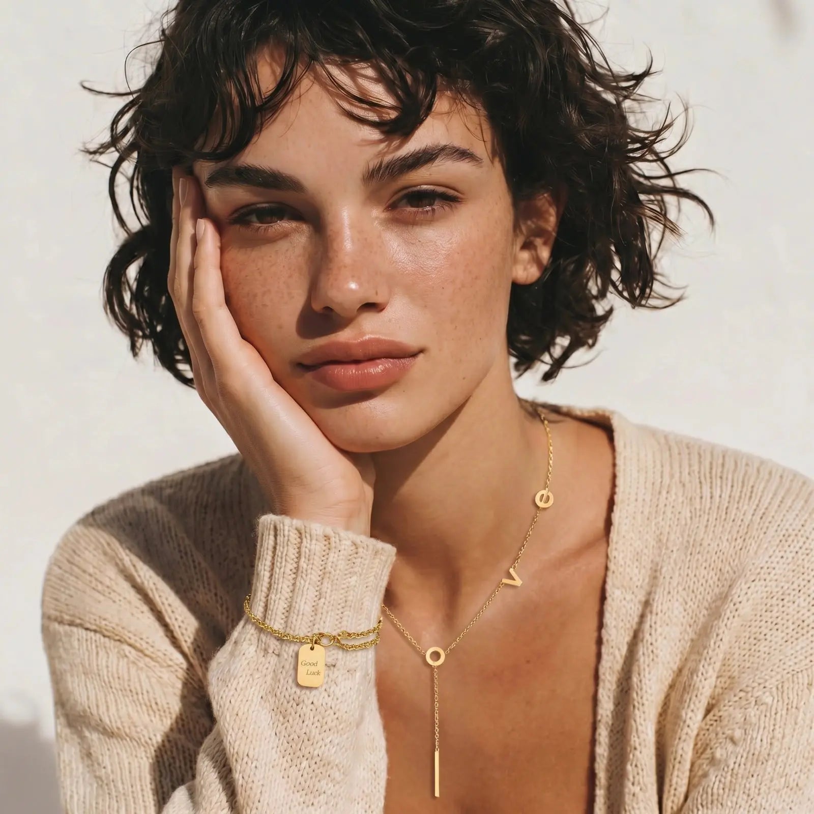 Woman wearing gold jewelry with a neutral background