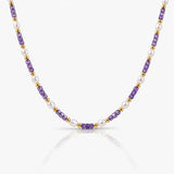 Necklace with purple, gold, and white beads on a white background