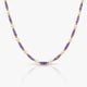Necklace with purple, gold, and white beads on a white background