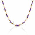 A beaded necklace featuring alternating strands of faceted purple amethyst beads, white freshwater pearls, and polished gold spacer beads, displayed on a clean white background with a soft reflection.