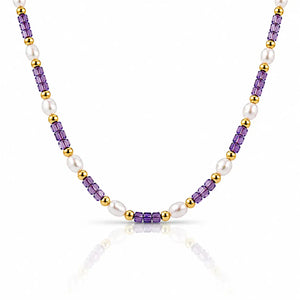 A beaded necklace featuring alternating strands of faceted purple amethyst beads, white freshwater pearls, and polished gold spacer beads, displayed on a clean white background with a soft reflection.