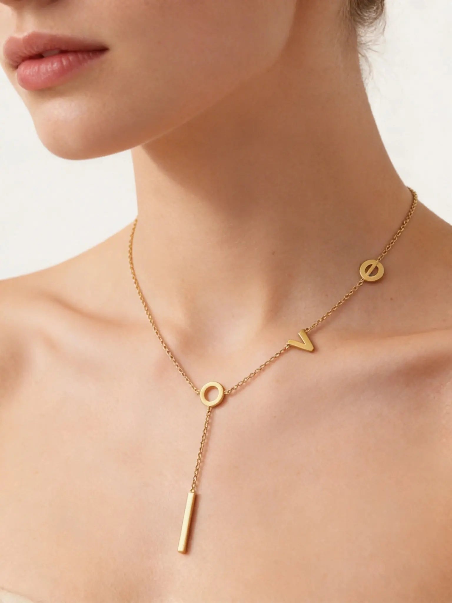 Model wearing 18K gold lariat necklace with LOVE letter charms, elegant minimalist jewelry