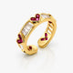 Gold ring with red gemstones on a white background