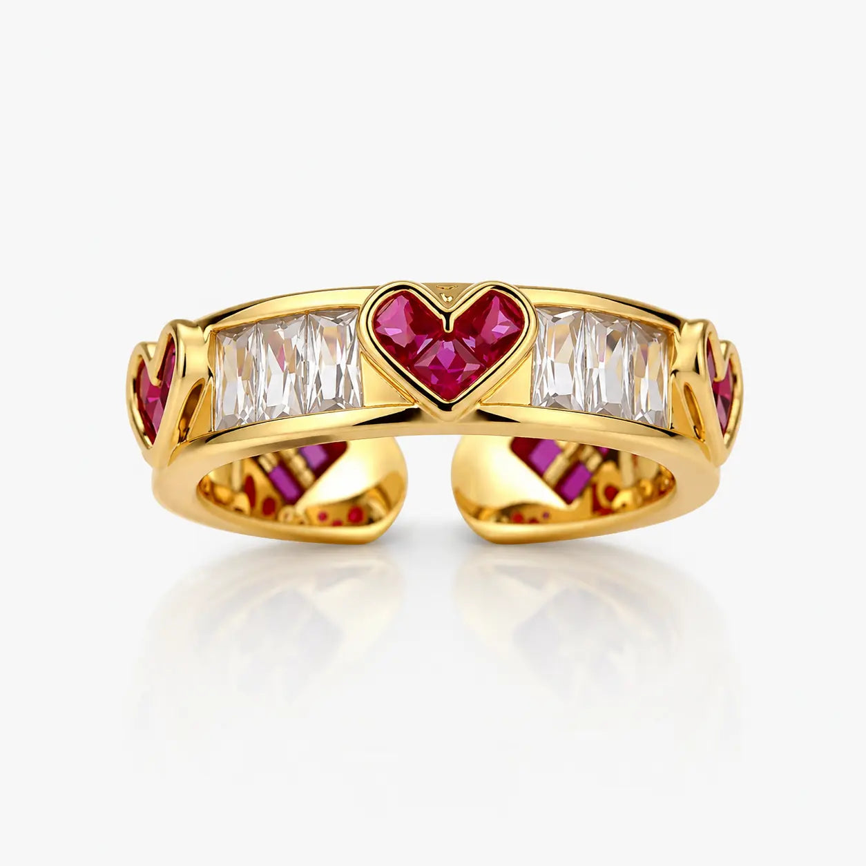 Gold ring with heart-shaped ruby and baguette-cut diamond design on a white background