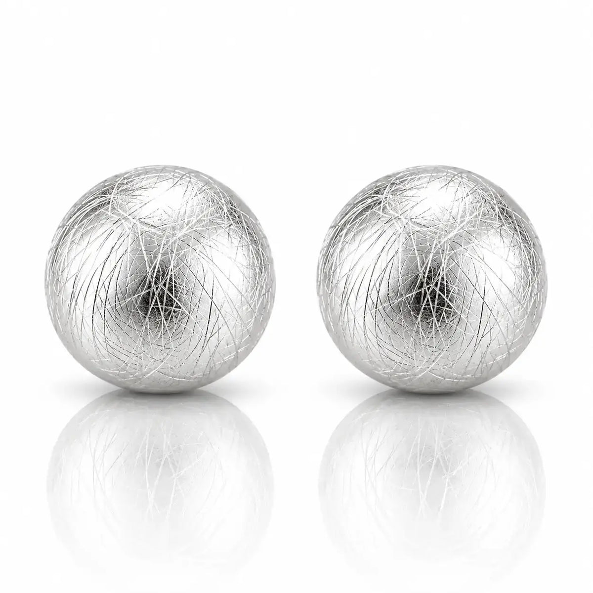 A pair of silver spherical earrings with a textured, fibrous outer layer, displayed on a reflective white surface against a white background.