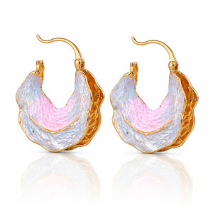 Gold hoop earrings with pink and white textured design on a white background