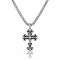 A silver-toned cross pendant necklace with a small clear stone set in the center, hanging from a matching chain against a white background with a soft reflection below.