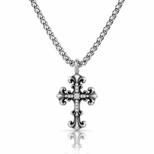 A silver-toned cross pendant necklace with a small clear stone set in the center, hanging from a matching chain against a white background with a soft reflection below.