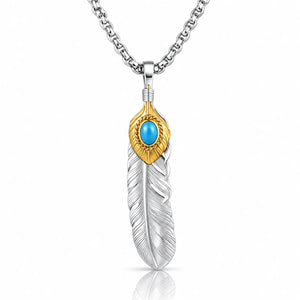A silver-toned feather pendant necklace with a textured silver feather body, a gold-toned top section, and a round turquoise blue stone in the center, suspended from a silver chain on a white background.