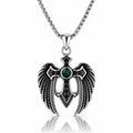 A silver-toned angel wing pendant necklace with a central green gemstone and black accents, suspended from a silver chain on a white background with a reflection below.