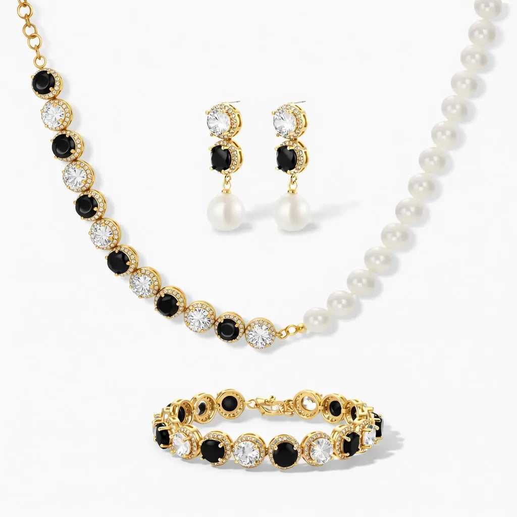 Gold jewelry set with black and clear gemstones, pearl necklace, and drop earrings.