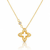 A gold necklace featuring a four-lobed clover or quatrefoil pendant with small clear gemstones set along the edges, suspended from a delicate gold chain with a small round stone accent, shown on a white background with a soft reflection below.