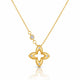 A gold necklace featuring a four-lobed clover or quatrefoil pendant with small clear gemstones set along the edges, suspended from a delicate gold chain with a small round stone accent, shown on a white background with a soft reflection below.