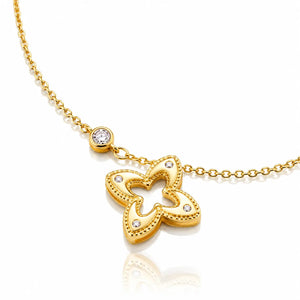 A gold chain necklace featuring a butterfly-shaped pendant adorned with small clear stones, shown on a clean white background with a soft reflection.