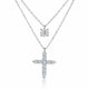 A silver-tone double-strand necklace featuring a small round solitaire pendant and a larger cross pendant paved with small clear stones, shown on a white background.
