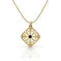 A gold filigree pendant necklace featuring a diamond-shaped openwork design with a central dark blue oval stone and small clear stones, shown on a white background with a soft reflection.