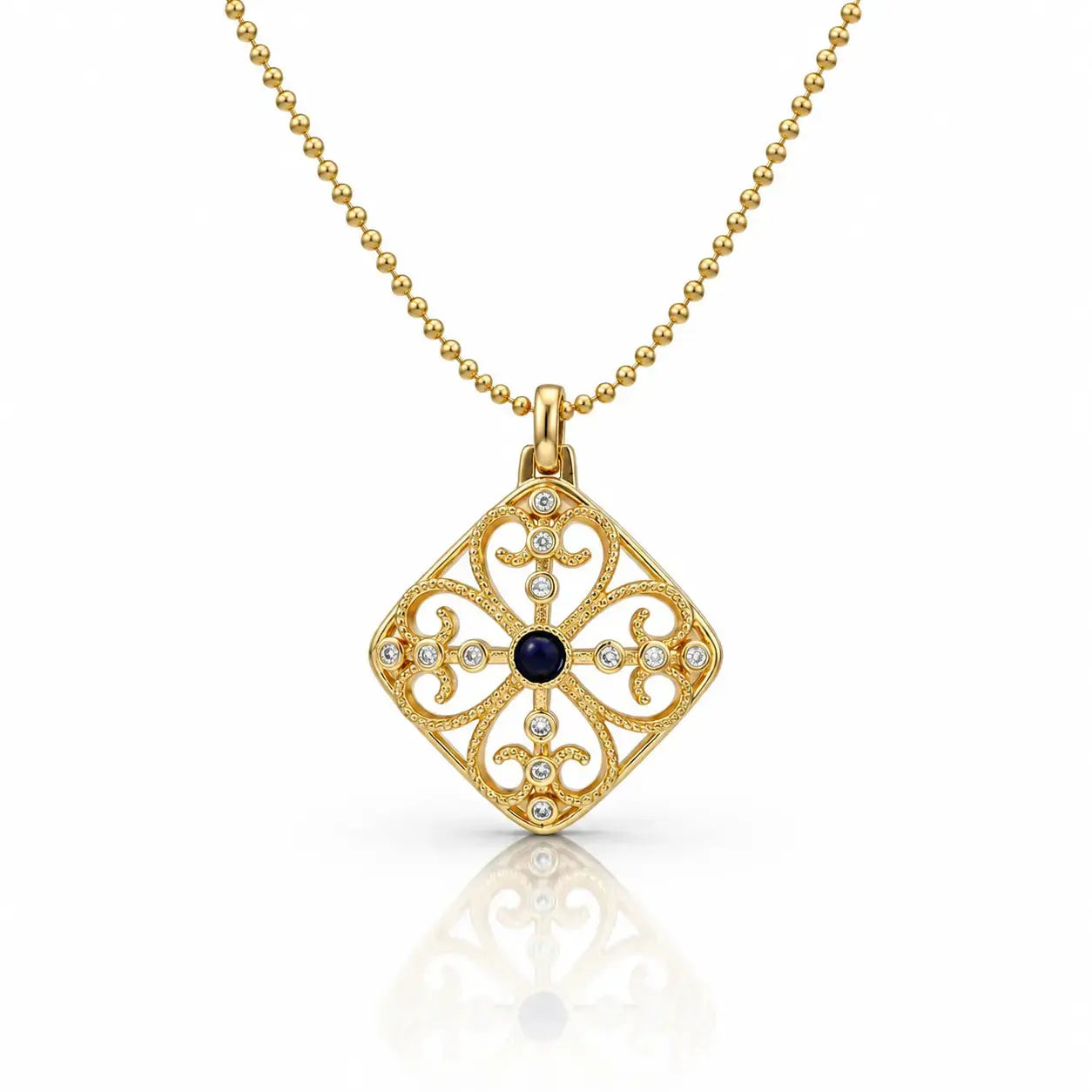 A gold filigree pendant necklace featuring a diamond-shaped openwork design with a central dark blue oval stone and small clear stones, shown on a white background with a soft reflection.