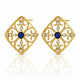 A pair of gold filigree stud earrings with a central deep blue gemstone and small clear rhinestones, displayed on a clean white background with a soft reflection below.