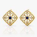 Gold earrings with blue gemstones on a white background