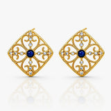 Gold earrings with blue gemstones on a white background