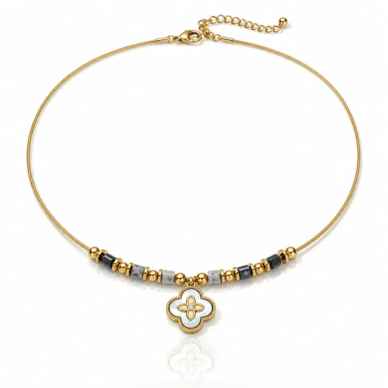 A gold-plated beaded necklace featuring a central white and gold four-leaf clover charm, accented with small gray beads, set against a clean white background.