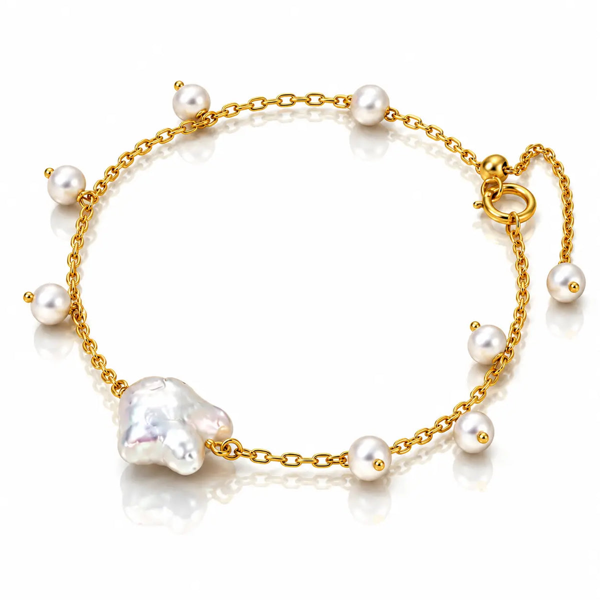 A delicate gold chain anklet featuring a large baroque pearl and several smaller white freshwater pearls, displayed on a clean white background.