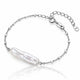 A silver chain bracelet featuring a large, lustrous baroque pearl pendant, displayed on a clean white background with a soft reflection.