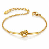 A gold chain bracelet with a central bar and knot design, featuring a lobster clasp and an adjustable chain extender engraved with the brand name 'TOKYO'.