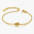 Gold bracelet with knot design on a white background
