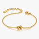 Gold bracelet with knot design on a white background